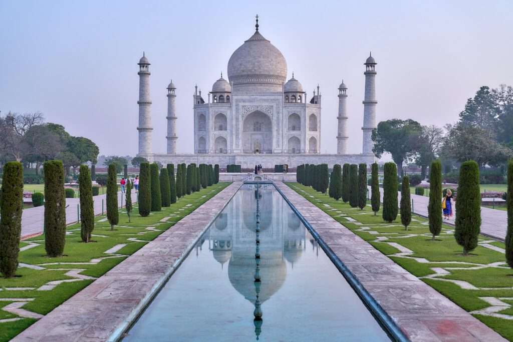 a long pool with a large building and trees with Taj Mahal. a great travelplace on our world and a rare sights. 