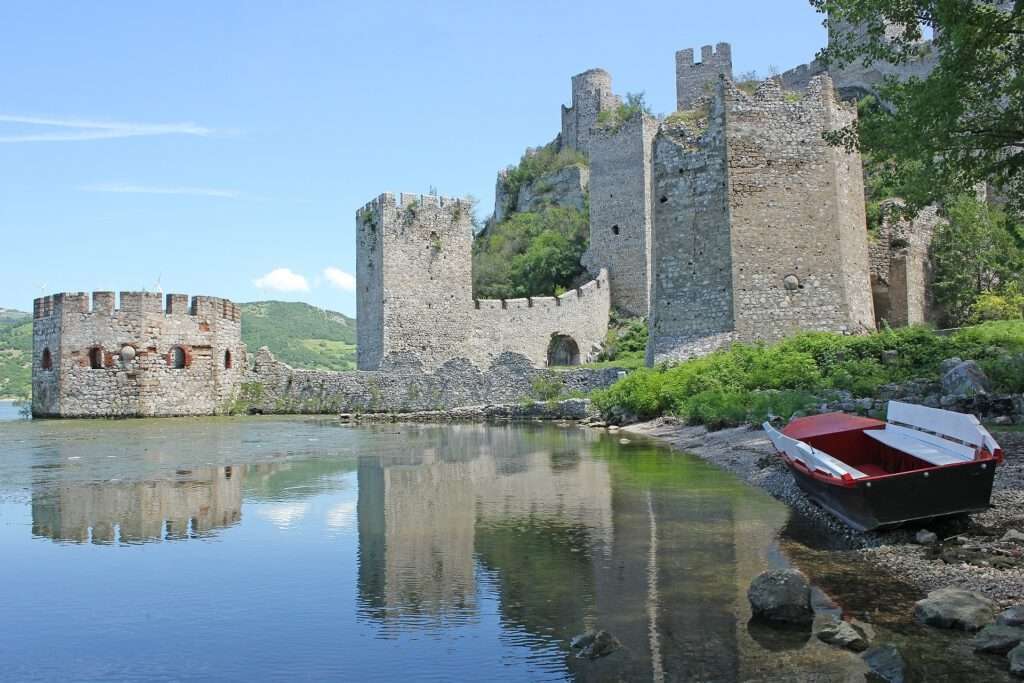 Travelgoals 2024 - An old castle, half in the water. A boat lies on its side in the foreground