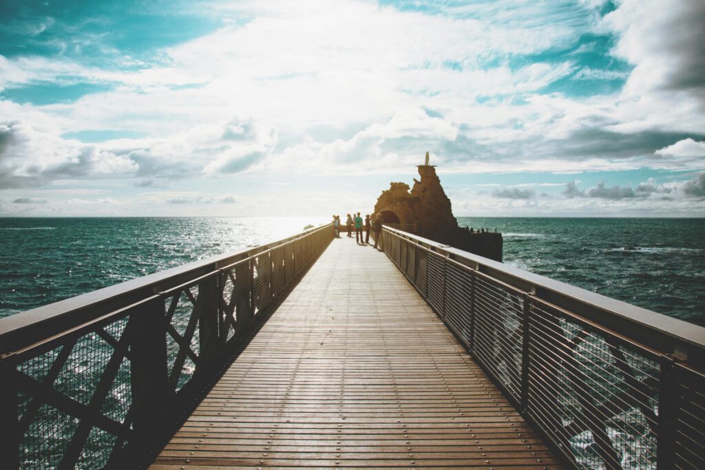 Travelgoals 2024 - A long footbridge into the water with a rock at the back on the right