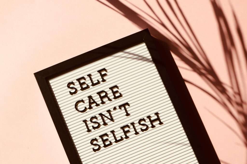 Dont vacation in England - a plat with the words self care isn`t selfish with a peach background